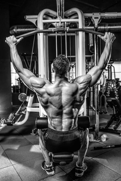 Bonito modelo jovem treinando de volta no ginásio — Fotografia de Stock