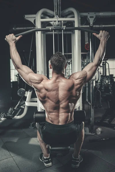 Handsome model young man training back in gym — Stock Photo, Image