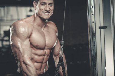 Yakışıklı model genç adam eğitim kollarında spor salonu