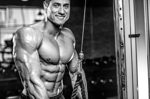 Gut aussehend modell junger mann training arms im fitnessstudio — Stockfoto