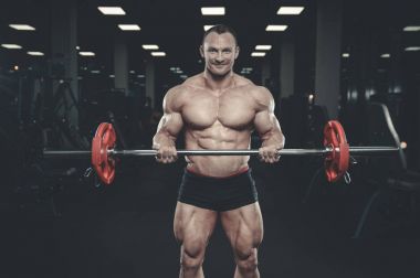 Yakışıklı model genç adam eğitim kollarında spor salonu