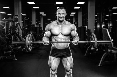 Yakışıklı model genç adam eğitim kollarında spor salonu