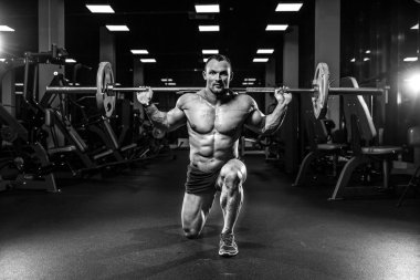 Yakışıklı model genç adam eğitim bacaklar içinde jimnastik salonu