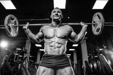 Yakışıklı model genç adam eğitim bacaklar içinde jimnastik salonu