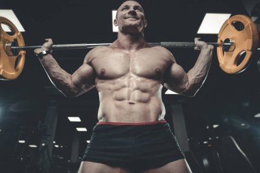 Yakışıklı model genç adam eğitim bacaklar içinde jimnastik salonu