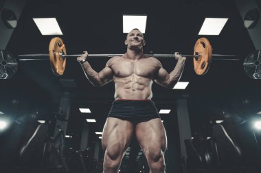 Yakışıklı model genç adam eğitim bacaklar içinde jimnastik salonu