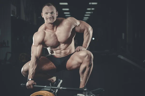 Bello modello giovane uomo in posa in palestra — Foto Stock