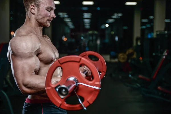 Knappe model jongeman opleiding wapens in sportschool — Stockfoto