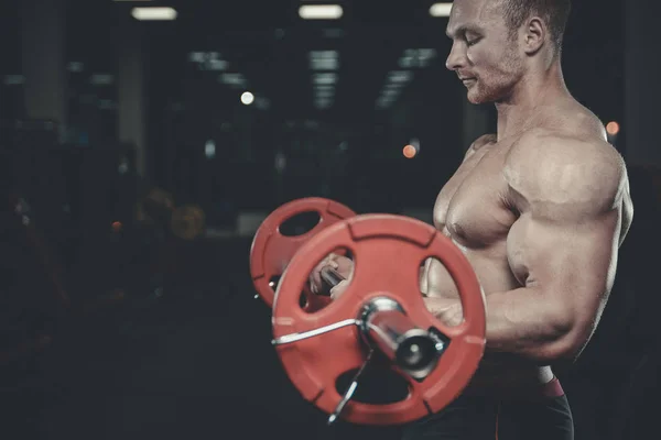 Gut aussehend modell junger mann training arms im fitnessstudio — Stockfoto