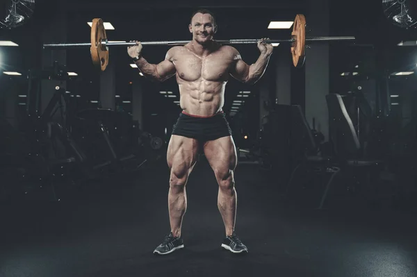 Schöner Modell junger Mann Training Beine in Turnhalle — Stockfoto