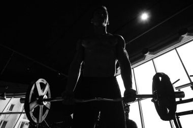 Yakışıklı model genç adam eğitim kollarında spor salonu