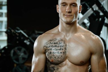 Yakışıklı model genç adam spor salonunda poz