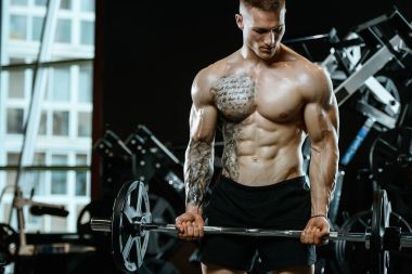 Yakışıklı model genç adam spor salonunda egzersiz