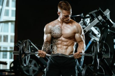 Yakışıklı model genç adam spor salonunda egzersiz