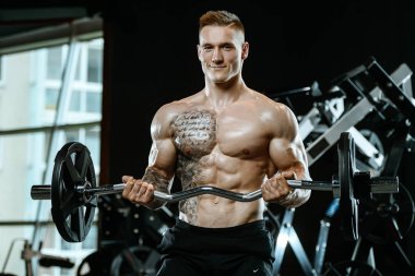 Yakışıklı model genç adam spor salonunda egzersiz