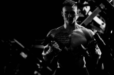 Yakışıklı model genç adam spor salonunda egzersiz