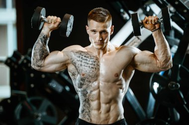 Yakışıklı model genç adam spor salonunda egzersiz