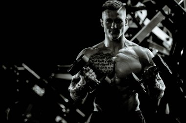 Yakışıklı model genç adam spor salonunda egzersiz