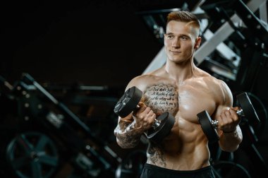 Yakışıklı model genç adam spor salonunda egzersiz