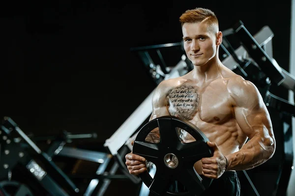 Yakışıklı model genç adam spor salonunda egzersiz — Stok fotoğraf