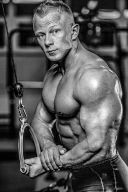 Yakışıklı model genç adam eğitim kollarında spor salonu