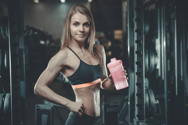 Sexy athletic young girl takes sport nutrition — Stock Photo, Image