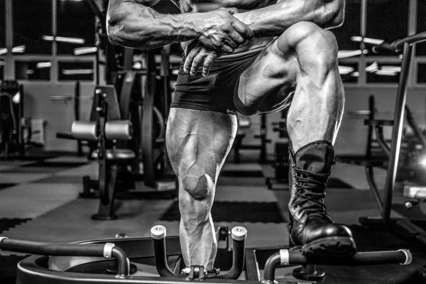 Beau modèle jeune homme d'entraînement jambes dans la salle de gym — Photo