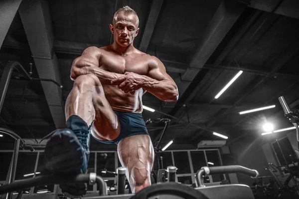 Knappe model jongeman opleiding benen in de sportschool — Stockfoto