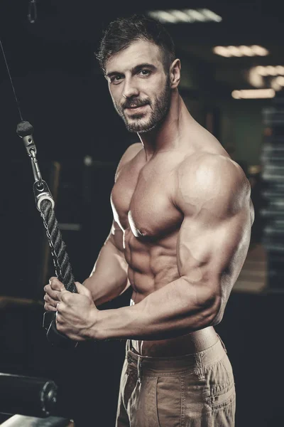 Yakışıklı model genç adam eğitim kollarında spor salonu — Stok fotoğraf