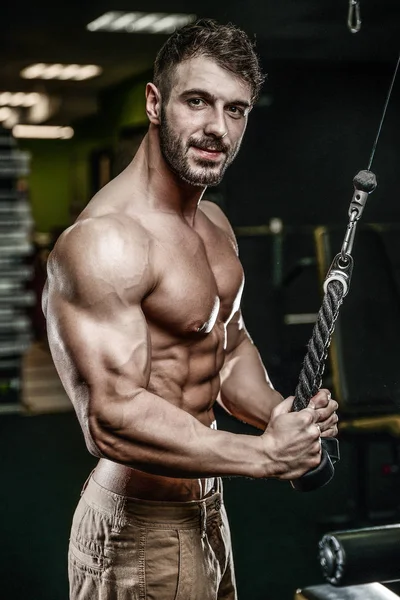 Yakışıklı model genç adam eğitim kollarında spor salonu — Stok fotoğraf