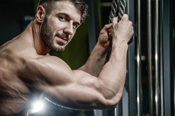 Yakışıklı model genç adam eğitim kollarında spor salonu — Stok fotoğraf