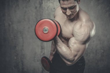 Model adam vücut geliştirmeci gri arka plan üzerinde poz