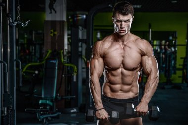 Yakışıklı model genç adam eğitim kollarında spor salonu