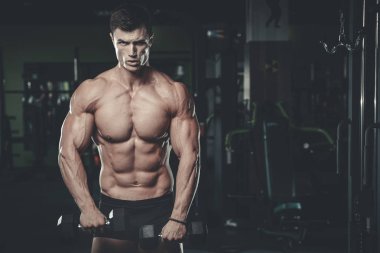 Yakışıklı model genç adam spor salonunda poz