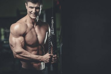 Yakışıklı model genç adam eğitim kollarında spor salonu