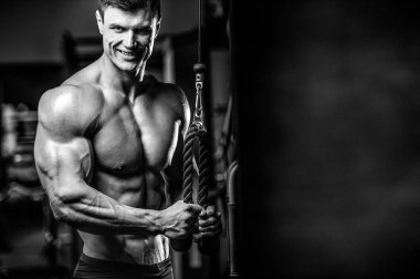 Yakışıklı model genç adam eğitim kollarında spor salonu