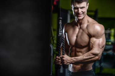 Yakışıklı model genç adam eğitim kollarında spor salonu