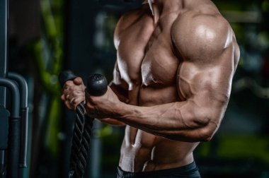 Yakışıklı model genç adam eğitim kollarında spor salonu