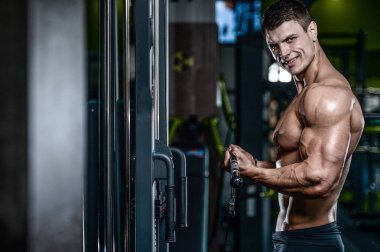 Yakışıklı model genç adam eğitim kollarında spor salonu