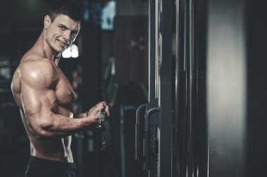 Yakışıklı model genç adam eğitim kollarında spor salonu