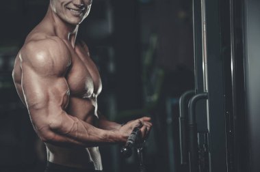 Yakışıklı model genç adam eğitim kollarında spor salonu