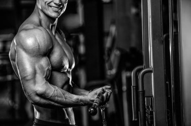 Yakışıklı model genç adam eğitim kollarında spor salonu