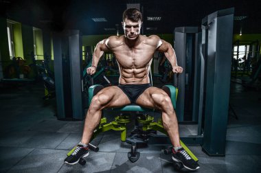 Yakışıklı model genç adam eğitim bacaklar içinde jimnastik salonu