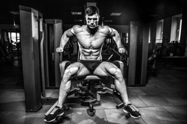 Yakışıklı model genç adam eğitim bacaklar içinde jimnastik salonu