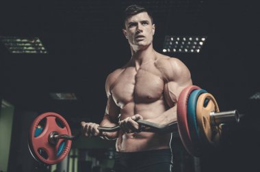 Yakışıklı model genç adam eğitim kollarında spor salonu