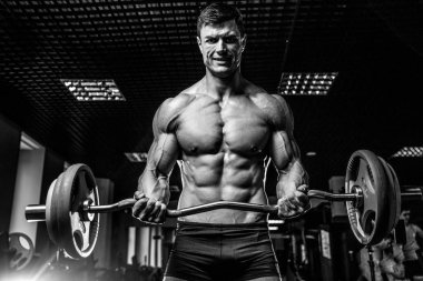 Yakışıklı model genç adam eğitim kollarında spor salonu