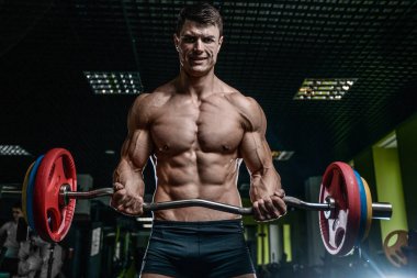 Yakışıklı model genç adam eğitim kollarında spor salonu