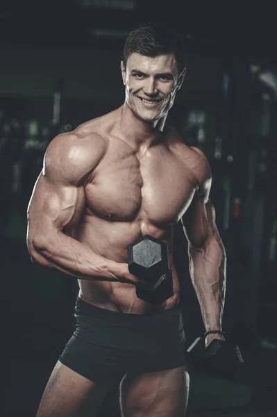 Handsome model young man training arms in gym — Stock Photo, Image