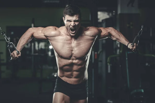 Atractivo modelo joven entrenamiento en el gimnasio —  Fotos de Stock