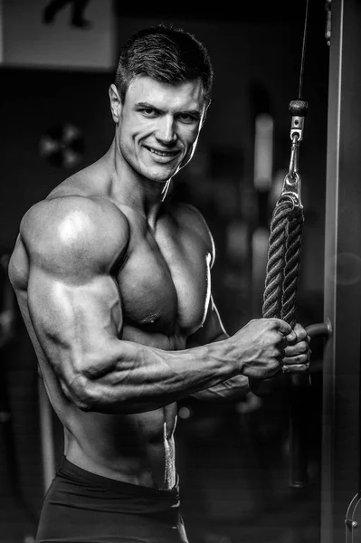 Bonito modelo jovem treinamento braços no ginásio — Fotografia de Stock